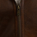 Close-up of a brown leather jacket with a zipper