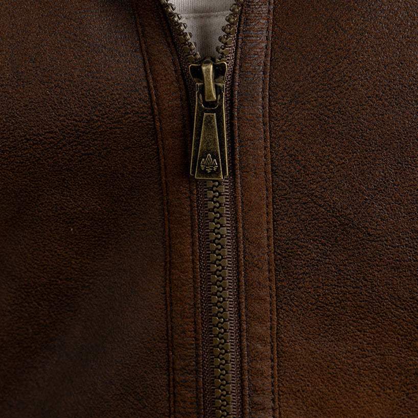 Close-up of a brown leather jacket with a zipper